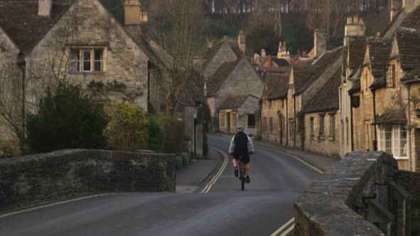 Biker passing through an old stone village in England.