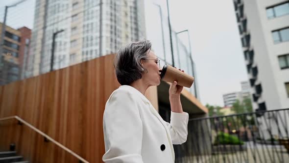 Beautiful Caucasian Elderly Grayhaired Business Woman Drinking Coffee Outdoors