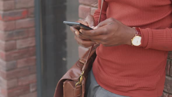 African American Man Texting on Smartphone Outdoors