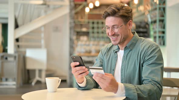 Designer Making Successful Online Payment on Smartphone in Cafe 