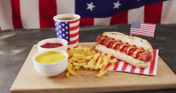 Video of hot dogs with mustard, ketchup and chips over flag of usa on a wooden surface