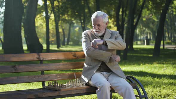 Old Man Sitting on Bench in Park Alone and Playing Chess, Retirement Benefits