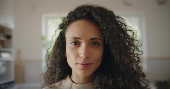 Woman with curly hair slightly smiling