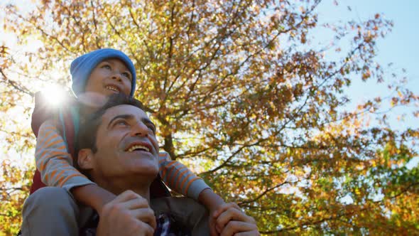 dad outdoors with son on back