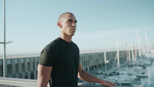 Bald handsome sportsman wearing black t-shirt walking outdoors