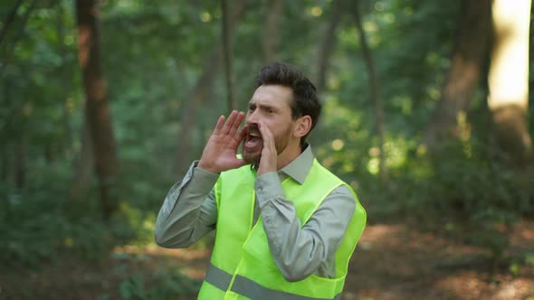 Middle Aged Man Volunteer Wearing Bright Green Vest Searching Missed Person in Wild Forest Shouting