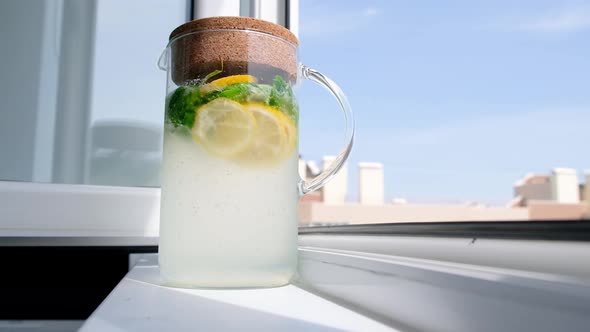 Homemade Lemonade in Glass Jug on Window