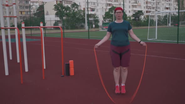 Fat Woman Jumping Rope to Lose Weight on an Outdoor Gym