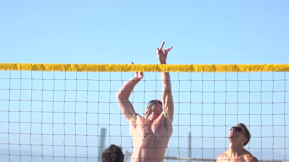 Men playing beach volleyball.