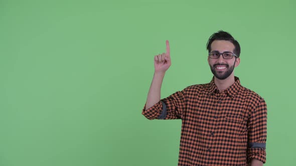 Happy Young Bearded Persian Hipster Man Talking and Pointing Up