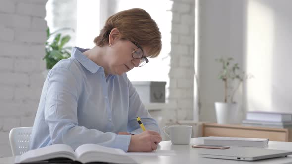 Old Woman Writing on Documents, Paperwork