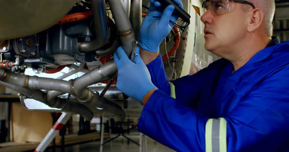 Engineer examining an aircraft engine in hangar 4k