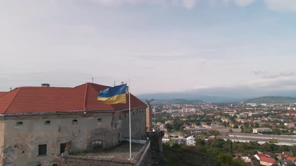 Ukrainian Flag Flies on Wall of an Ancient Medieval Castle in Small European City