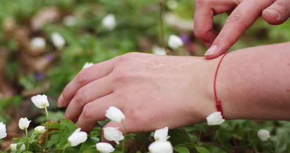 a drop of serum falls on the hand, female fingers smear rub the serum into the wrist against