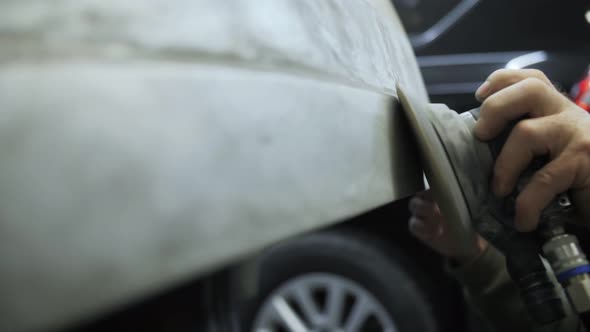 polishing of the damaged car door with a grinder