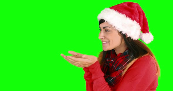 Festive brunette in santa hat blowing over hands 4k