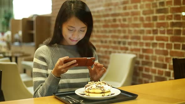 Woman taking photo with her cake before eating