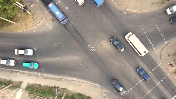 Top down aerial view of city traffic with cars moving on a street at roads intersection.