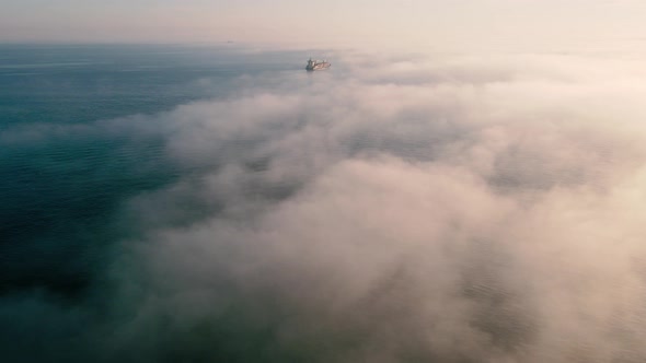 Aerial shot of  sea in foggy day with cargo ships