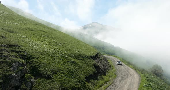 Driving On The Road At The Mountain Edge At Tskhratskaro Pass During Misty Morning In Georgia. Aeria