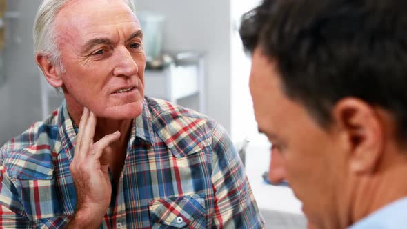 Doctor consoling senior man