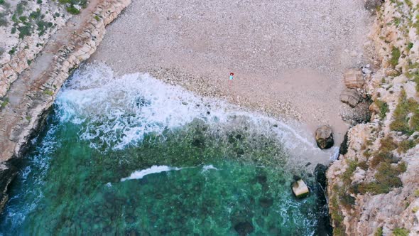 Top View of Young Woman Lying on Pebble Beach Near Sea Waves