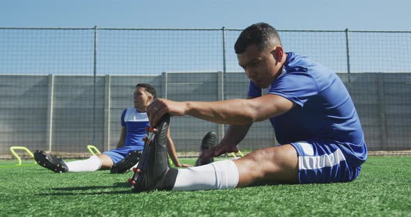 Soccer players stretching on field