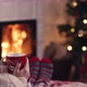 Over shoulder woman relax near fireplace cup tee in christmas woolen socks decorated tree in backg - VideoHive Item for Sale