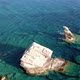 Aerial Footage of Three Pillars on a Rocky Coast with Clear Blue Water - VideoHive Item for Sale