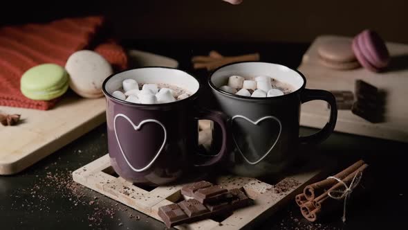 Man Putting Marshmallows Into a Cup of Cocoa