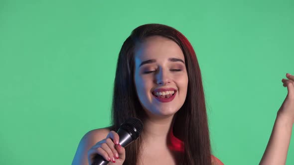 Portrait of Beautiful Young Woman Illuminated By Blue Red Neon Light Sings Song Into Microphone