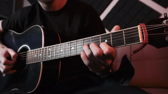 Young Man Playing Acoustic Guitar While Sitting Sofa Home Recording Studio