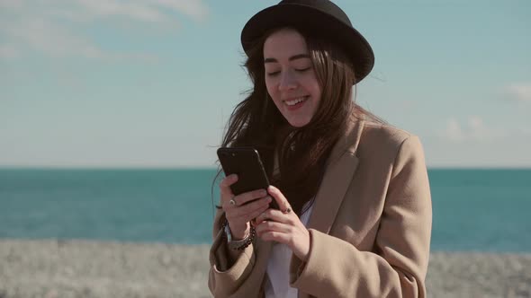 Happy Girl on a Beach with a Phone.