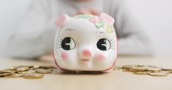 Woman putting coins into piggy bank