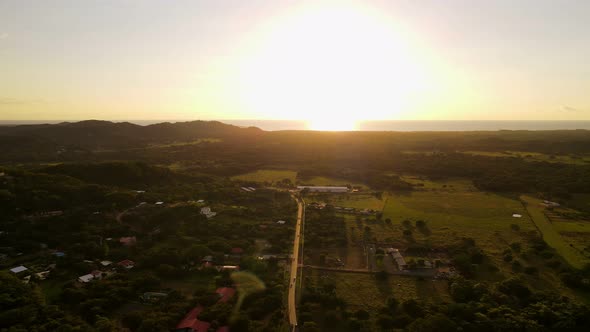 Still aerial video of a busy country road leading towards the ocean in central America. Bright and v