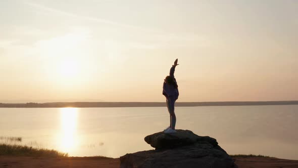 A Girl Does Fitness on a Hill at Sunset