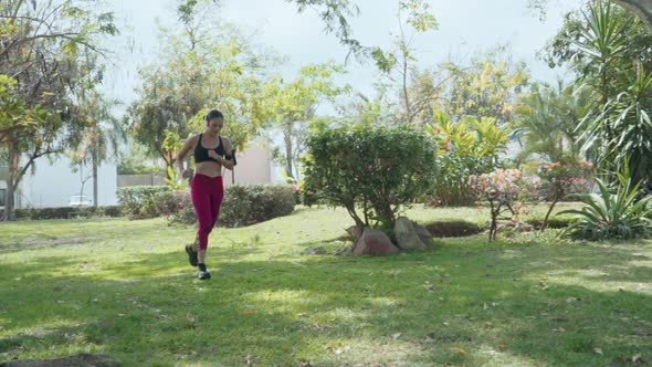 Mexican Woman with Headphones Running in the Park