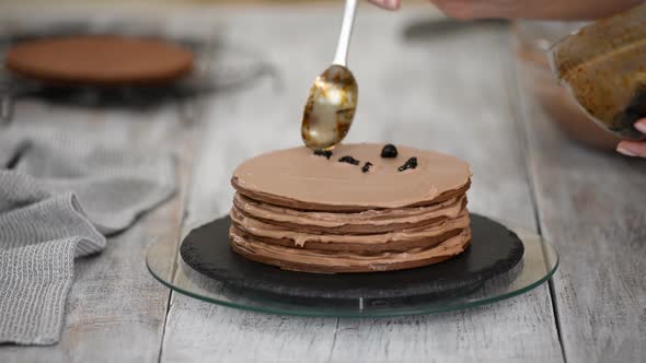 Step by step. Pastry chef making chocolate layer cake with prune filling.	