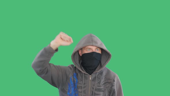 Protestant Gesticulating Fists Social Rally on Green Background. Furious Man in Bandana and Hood