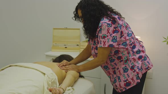 Masseuse Giving Another Woman an Upper Back Massage in Spa