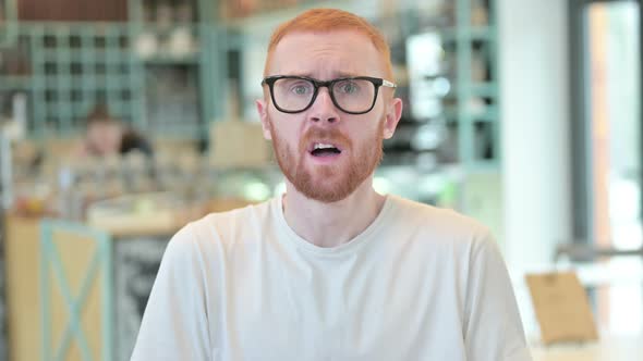 Portrait of Disappointed Redhead Man Reacting To Loss