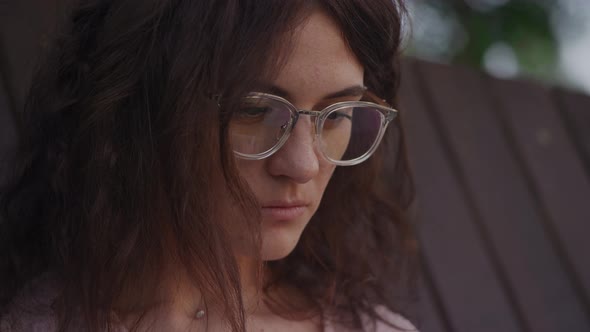 Handheld Close Up of a Curly Caucasian Woman Looking at the Laptop Reflection in Her Glasses