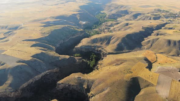 Aerial Deep Long Rift Canyon with Cleft Steep Rock Walls and High Cliff Gorge