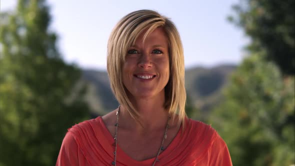 Static shot of attracive blond woman smiling in a light breeze