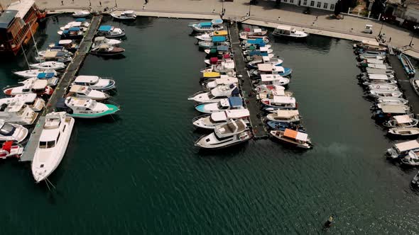 Aerial top down view of sea dock with colorful boats. Top view harbor. Travel