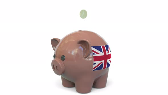 Putting Money Into Piggy Bank with Flag of the United Kingdom