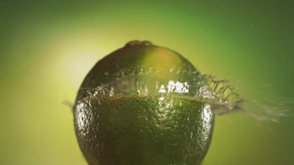 Half Lime Falling and Splashing on Green Background
