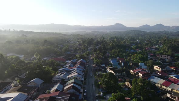 Aerial view fly over small town near the green plantation