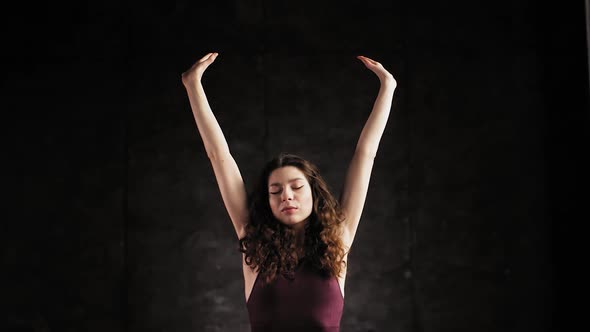 The Medium Shot of a Young Girl in a Dark Room and Meditation in the Style of Yoga. Shoot in Slow