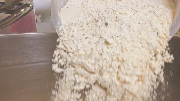 Sprinkling Flour Into a Kneading Machine